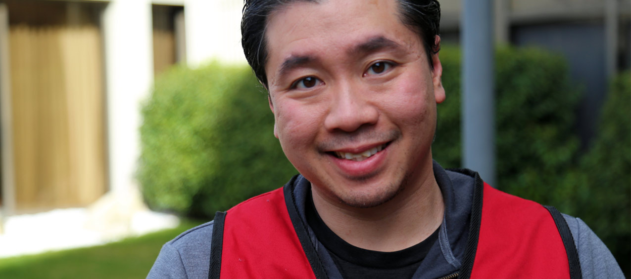 A Red Cross volunteer smiles warmly at the camera.