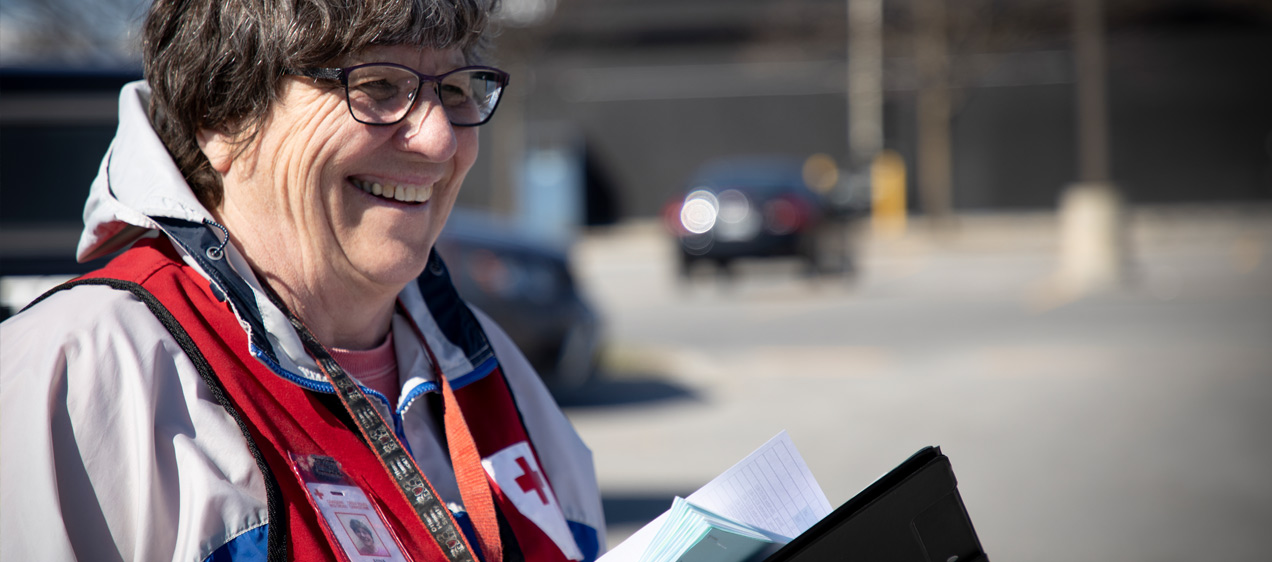 Une femme portant un gilet de la Croix-Rouge Canada souriante