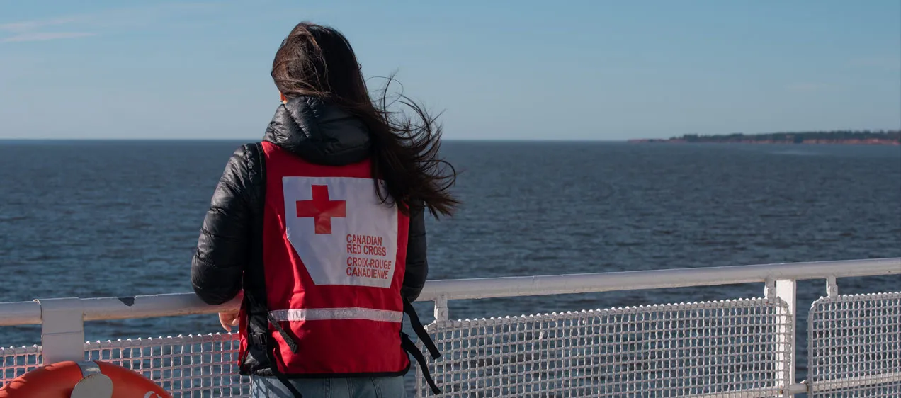 Andrea Parent, membre de la Croix-Rouge canadienne, porte un gilet rouge alors qu'elle voyage à bord d'un traversier sur l'Atlantique.