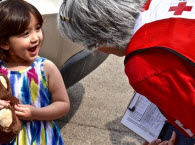 Red Cross volunteer talking to young girl