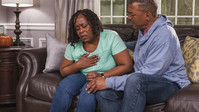 Une personne qui éprouve un malaise se touche la poitrine, un signe possible d’une crise cardiaque.