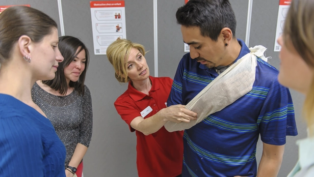 Person applying a bandage to someone else's arm to treat a minor injury.