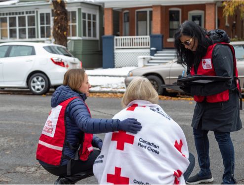 Canadian Red Cross volunteers comforting a woman on the streets 