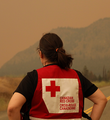 Une file de personnes vêtues de rouge se passent du matériel d’aide d’urgence.