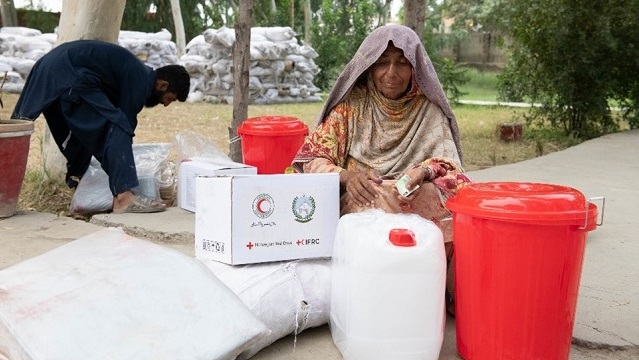 Une femme reçoit des fournitures de la Croix-Rouge