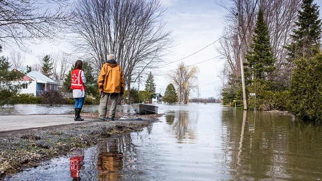 Deux personnes regardent une rue inondée