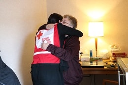 red cross volunteer hugs family facing floods two years in a row