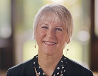 Woman with white hair, beautiful smile and a polka dot scarf