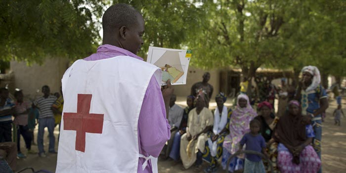 An international delegate giving instructions to a group of people in an African country