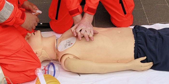 Deux personnes préformant des compressions de RCR sur un mannequin.