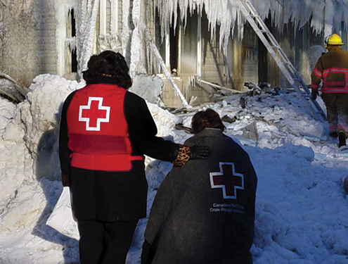 A Canadian Red Cross volunteer supporting a person who lost their house during a fire