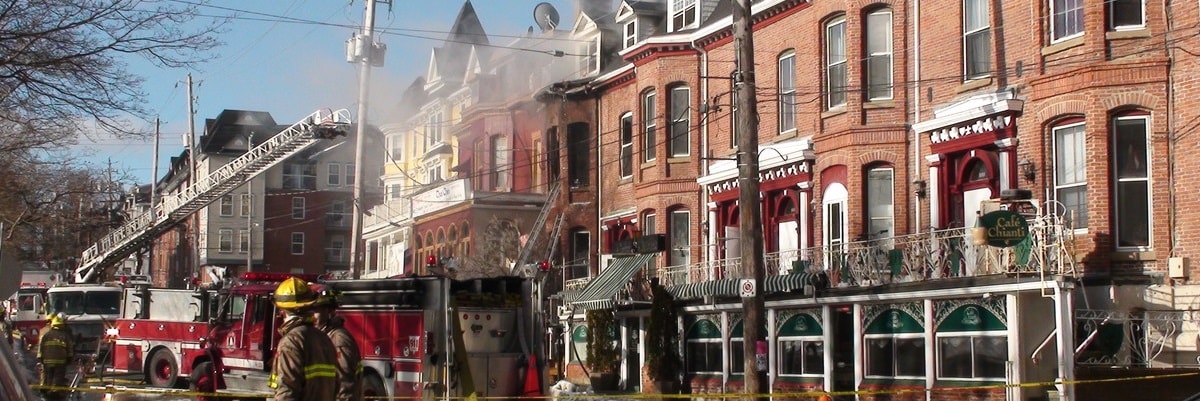 A fire engine parked in front of a row of houses